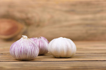 Several heads of garlic on a wooden background.