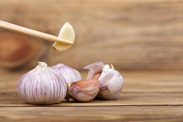 Wooden chopsticks with a clove of garlic.