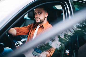 Concentrated man sitting in new car