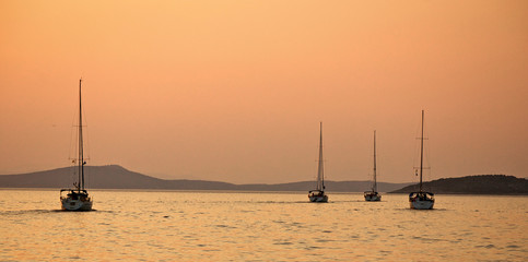 Flotilla sailing on sunset in Mediterranean sea