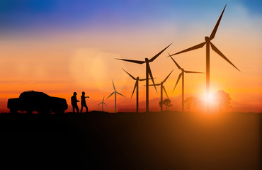 Silhouette of engineer and Maintenance team working Maintenance of wind turbines is a clean energy that is widely used today. over blurred background sunset  for industry background with Light fair.