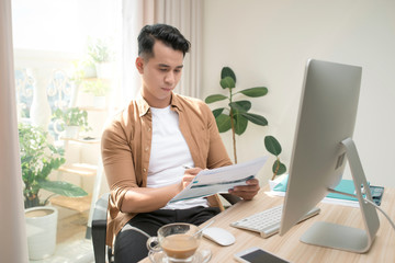 business and people concept - businessman with papers and laptop computer working at office