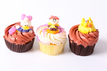 A colorful cupcake with doll on top , isolated