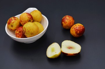 Dates cut in a white plate on a black background