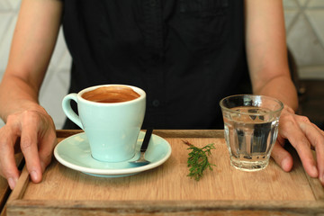 Americano coffee with woman hand on table.