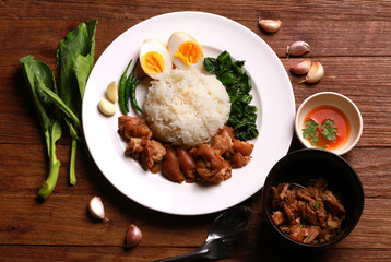 Stewed pork leg on rice on wooden table.Thai food