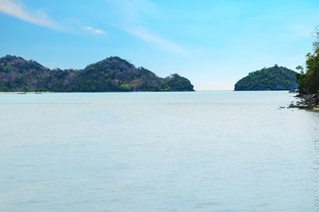 Beautiful seascape with the island on the background of blue sky on sun shine day.