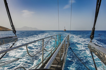 Shiny steel stairway at the back of the ship and another ship in horizon