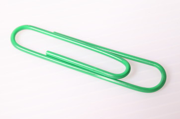 Green paper clip isolated on white
