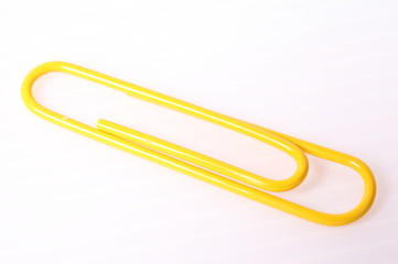 Yellow paper clip isolated on white