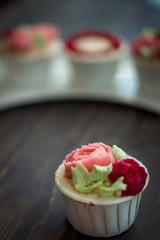 Beautiful cup cakes flowers from butter cream, in red and pink colour. Suitable for Birthday, Anniversary, Valentine Day and festive. selective focus