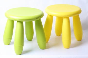 Small green and yellow plastic stool for kids isolated on white
