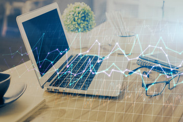 Double exposure of graph and financial info and work space with computer background. Concept of international online trading.