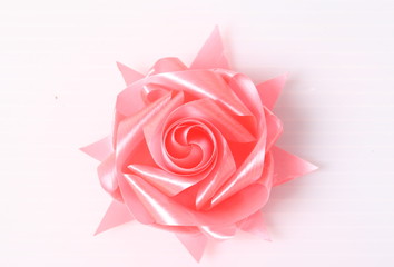 pink ribbon flower made with folded hands on white background with clipping path