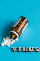 Virus treatment concept. Pills and the inscription virus on a blue background. copy space. vertical photo
