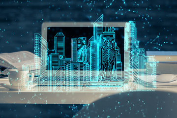 Desktop computer background in office and big town buildings hologram drawing. Double exposure. Smart city concept.