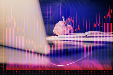 Double exposure of businessman with laptop and stock market forex chart.