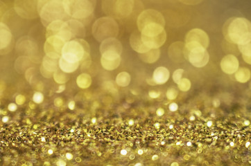 Glitter gold background. Christmas texture with shining Golden circle bokeh as  abstract pattern of light color for festive holiday design