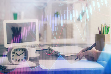 Financial graph displayed on woman's hand taking notes background. Concept of research. Multi exposure