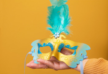 hand holding carnival mask with background, happy carnival day