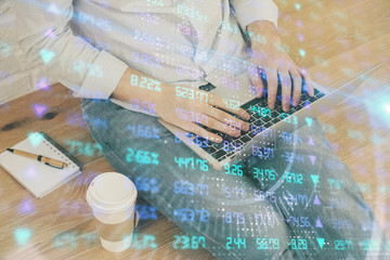 Forex graph with businessman working on computer in office on background. Concept of analysis. Double exposure.