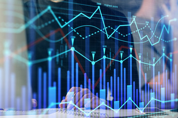 Forex graph with businessman typing on computer in office on background. Concept of analysis. Double exposure.