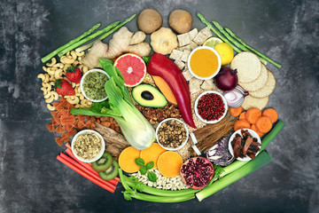 Fototapeta na wymiar Super food for a healthy eating concept with health foods and herbal medicine high in antioxidants, anthocyanins, vitamins, minerals, protein, omega 3 and fibre. Flat lay on grunge background.