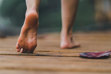 barefoot girl with walking on the bridge wood with blur background outdoor nature