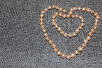 Heart made of pearls on a gray background. Heart made of beads. Heart for valentines day.