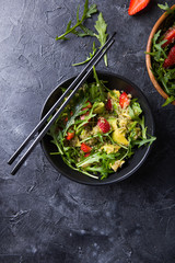 Arugula Salad with  quinoa, strawberry,  honey and chia seeds. Concept vegan and healthy eating. Top view. Diet dinner or lunch menu.