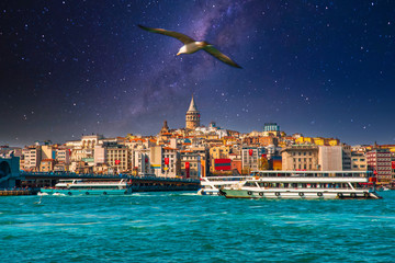 Fototapeta premium Wieża Galata w Stambule w Turcji. Widok na miasto Stambuł w Turcji z Bosfor, mewy i łodzie na jasne niebo i zachód słońca lub w nocy.
