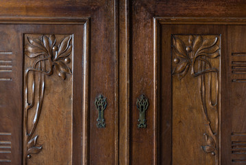 A picture of a wooden carved door of an antique closet cupboard retro house