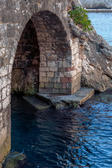 Ancient brick arch under the fortress with bottom beneath the water in Old town Dubrovnik