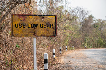Old traffic signs are rusty USE lOW GEAR and steep warning signs  for trucks on the Mountains
