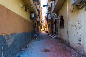 Alley in a residential area of the poorer population in Luxor, Egypt. No paved roads, just sand. - 321636684