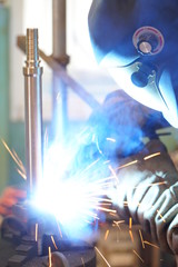 Metal workers use manual labor, Skilled welder, Factory workers making OT, The welder is welding the steel in the factory, Welding fumes, The welder stands to weld the iron in the dark