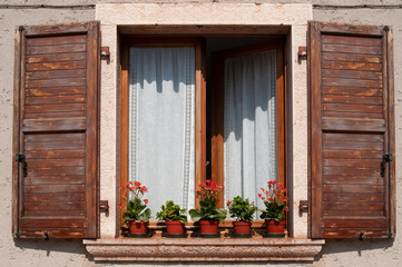 Fototapeta na wymiar window with wooden shutters and flower pots