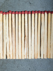 A bunch of matchsticks on a gray background