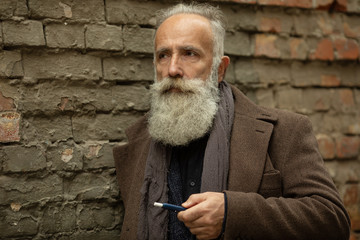 Senior man with beard breathe out smoke. Smoking electronic cigarette. Stress relief concept. Smoking device. Man long beard relaxed with smoking habit. Bearded man vaping. IQOS.