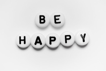BE HAPPY written on white circles isolated on a white background.