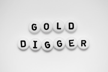 GOLD DIGGER written on white circles isolated on a white background.