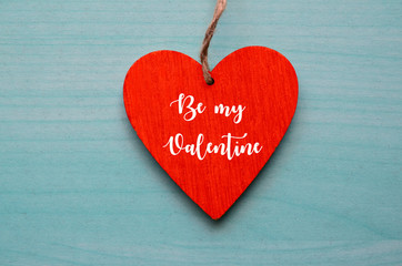 Valentine's Day greeting card.Decorative red heart with text Be My Valentine on a blue wooden background.February 14 concept.Selective focus.