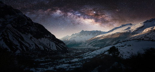 Plakat Night panorama of Milky Way over the snowy mountains in winter.