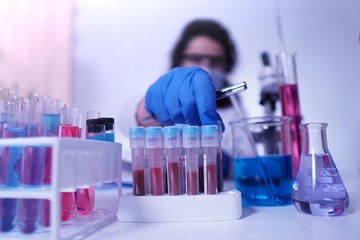 female lab technician doing research with a microscope in the lab.