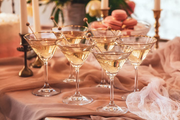 crystal martini glasses and sugar crystals on a festive table in beige colors