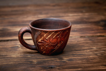 Brown clay cup on a dark wooden table_
