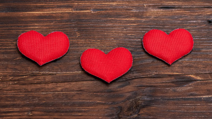 Handmade red hearts on dark wooden background_