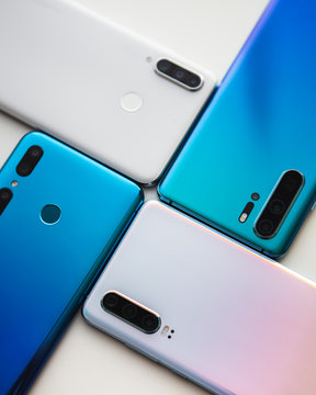 Spiral from colorful modern smartphones isolated in white background. Blue, white and gold phones.