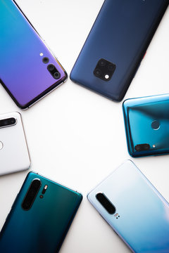Spiral from colorful modern smartphones isolated in white background. Blue, white and gold phones.