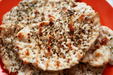 chicken fillet chop fried on a grill pan lying on a red plate